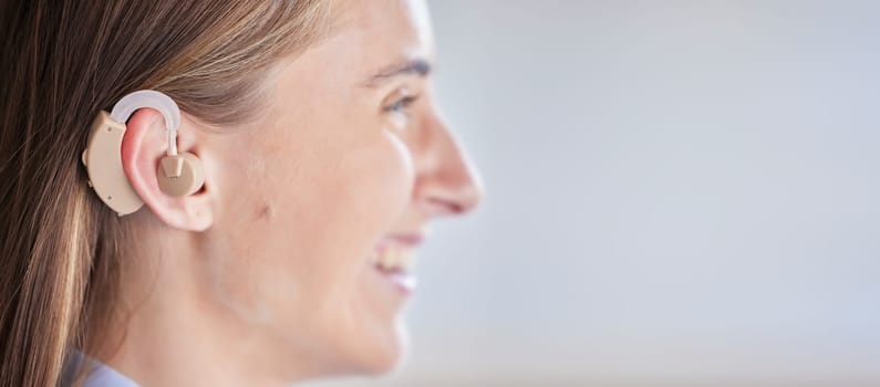 Mockup, deaf and woman with ear piece, disability and health against a grey studio background. Female, lady and hearing aid for help, success with tech and happiness with listening device and medical.