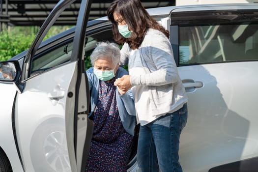 Caregiver help and support asian elderly woman sitting on wheelchair prepare get to her car to travel in holiday.
