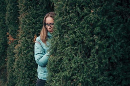 Autumn portrait of beautiful woman on thuja nature background