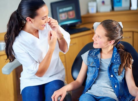 Have you been flossing. a female dentist and child in a dentist office