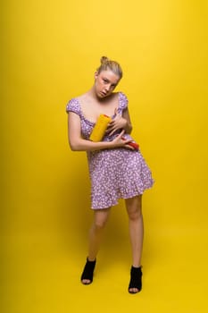 Beautiful blonde model wearing short dress bodysuit is holding a roller brush.