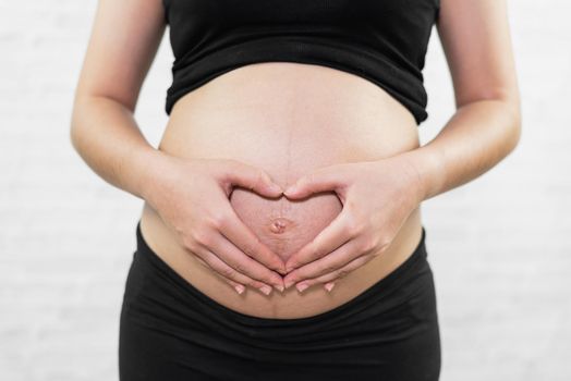 pregnant women holding belly heart shape on white background, pregnant women concept