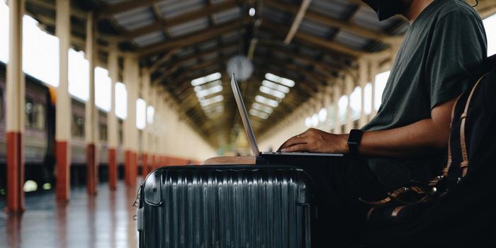 Image of Young freelance working at train station before travel. work and travel concept.