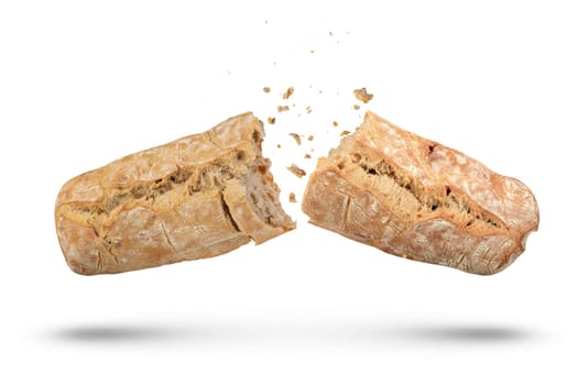 A loaf of Italian fresh ciabatta bread is broken into 2 parts on a white isolated background. Ciabatta bread isolate on a white background, bread crumbs scatter in different directions. side view