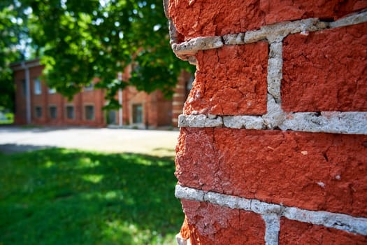 Corner of a red brick fence in the park close-up