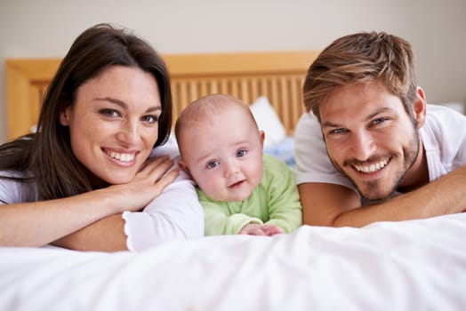 Happy portrait of mother, father and baby on bed for love, care and fun quality time together at home. Parents, cute newborn child and family bonding to relax in bedroom for support, happiness or joy.