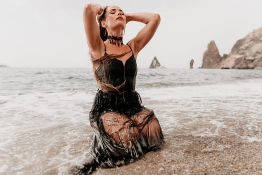 Woman travel sea. Young Happy woman in a long red dress posing on a beach near the sea on background of volcanic rocks, like in Iceland, sharing travel adventure journey