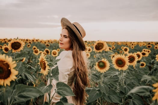 Woman in the sunflowers field. Summer time. Young beautiful woman standing in sunflower field.