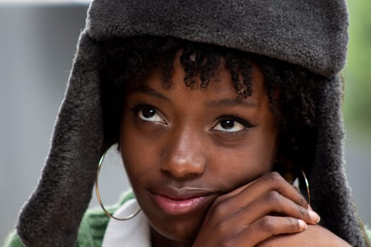 closeup of pretty african american girl in russian military hat looking up and thoughtful. High quality photo