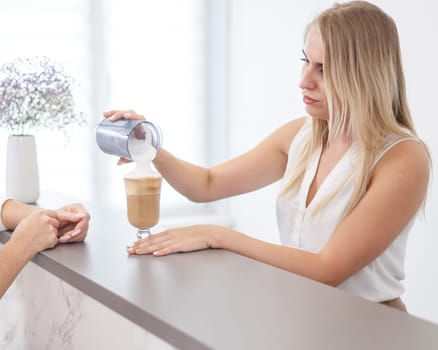 Receptionist in a beauty salon prepares coffee for a client