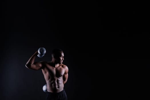 Portrait of happy african man with dumbbells over red and black background