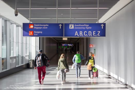 Unrecognizable People With Bags And Suitcase Walking In Airport Terminal. Rear View Of Passengers On Their Way To Flight Boarding Gate, Ready For Business Travel Or Vacation Journey