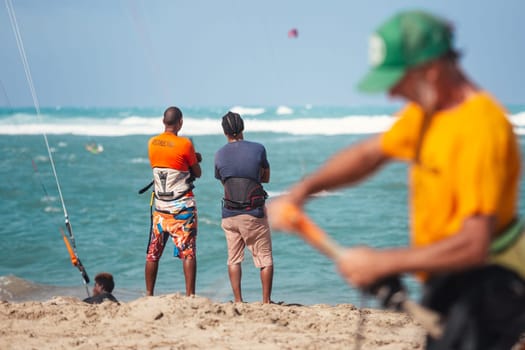 Active sporty people enjoying kitesurfing holidays and activities on perfect sunny day on Cabarete tropical sandy beach in Dominican Republic