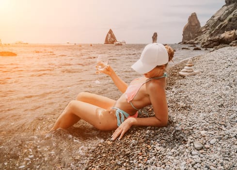 Woman travel sea. Young Happy woman in a long red dress posing on a beach near the sea on background of volcanic rocks, like in Iceland, sharing travel adventure journey