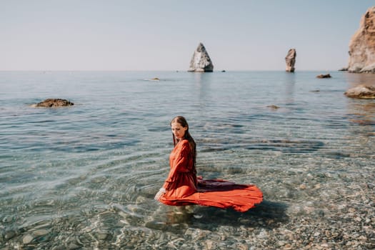 Woman travel sea. Happy tourist taking picture outdoors for memories. Woman traveler looks at the edge of the cliff on the sea bay of mountains, sharing travel adventure journey.