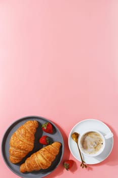 Delicious breakfast with fresh croissants, coffee and fresh berries on a pink background. copy space