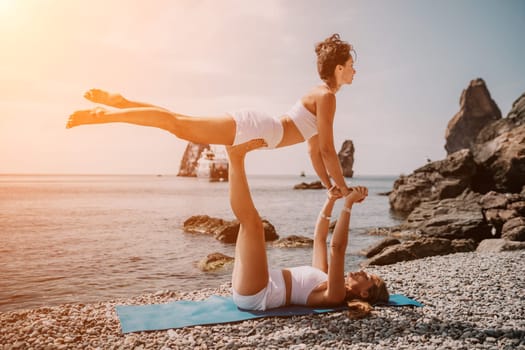 Woman sea yoga. Back view of free calm happy satisfied woman with long hair standing on top rock with yoga position against of sky by the sea. Healthy lifestyle outdoors in nature, fitness concept.