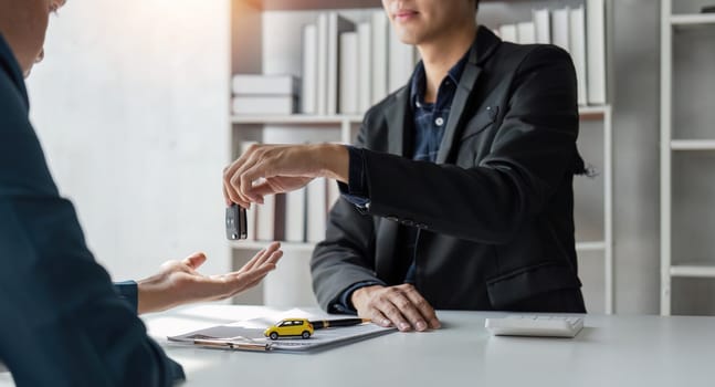 Loan approver, businessman giving car keys after car loan approval and contract signing.