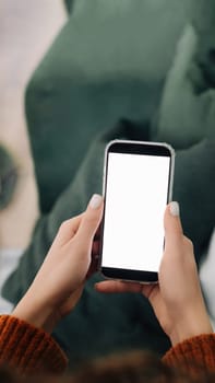 Relaxed Woman Using Smartphone Apps on Sofa at Home - Over Shoulder View with Cellphone Display Mock Up for Advertising Concept.