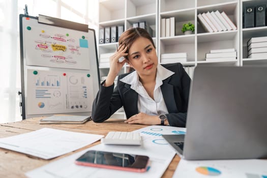 Asian business women are stressed while working on laptop and pile of documents, Tired asian businesswoman with headache at office, feeling sick at work.