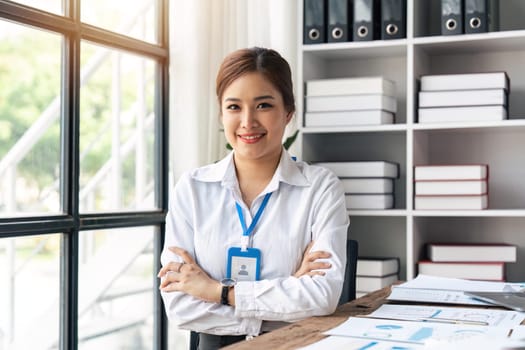 Portrait of smiling beautiful business asian woman with working in office desk using laptop.