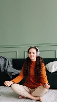 Mindful woman finding inner peace through yoga and meditation with calming music and podcasts. Relaxing at home with yoga and meditation: young woman finding mental balance.