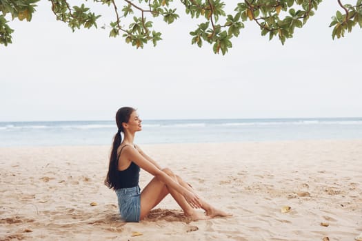 woman attractive white long caucasian travel nature beach pretty summer lifestyle sea sitting young alone carefree back smile freedom view hair sand vacation