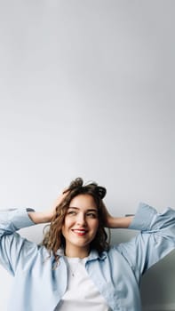 Image of attractive happy cheerful female student with curly hair and sincere smile enjoying weekend morning at home, dancing in kitchen, feeling carefree and relaxed, looking away.