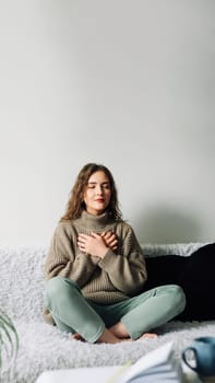 Relaxation techniques: Woman practicing pranayama in lotus position on bed, breathing exercises to reduce stress and anxiety, achieving inner balance and harmony, mindfulness and meditation practice.