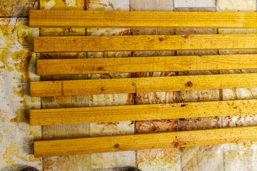 wooden boards treated with protective compounds. painted wooden slats dry on the floor in the workshop. Treatment of wood with a protective compound. Construction, home improvement.