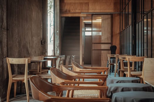The View of an Empty Cafe's Terrace are decorated with Wooden Tables and Wooden Chairs. Exterior of the Cozy Cafe in the Loft Style, Space for text, Selective focus.