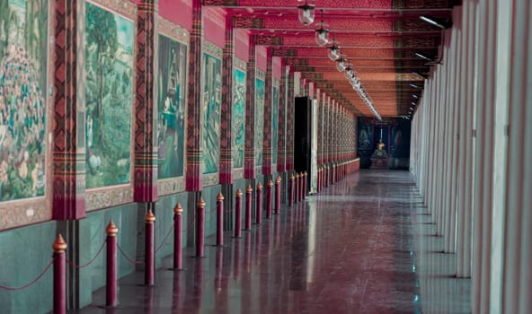 Suphan buri, Thailand Apr 22, 2023 - A Diminishing Perspective Interior View of Walkway at Wat Pa Lelai Worawihan (Pa Lelai Worawihan Temple) with Buddhist Temple Mural Painting Wall Decorated (Khun Chang Khun Phaen classical literature). Thai Art and Architecture Concept, Selective focus.