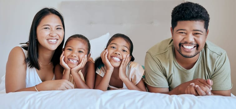 Happy, relax and family on a bed for peace, calm and smile together in their house. Portrait of young, excited and funny children in the bedroom with their mother and father for happiness and love.