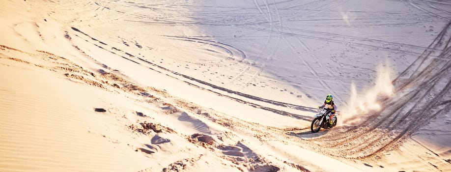 Sand, mockup and motorcycle with a sports man riding offroad on dunes outdoor in nature for recreation. Desert, bike and mock up with a male athlete taking a ride for fun, freedom or adventure.