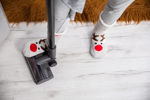 An overhead view of a foot trampling a vacuum cleaner tip. Keeping things tidy by frequently cleaning the floorboards.