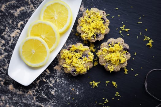 lemon cupcakes on a black background and a lemon on a plate