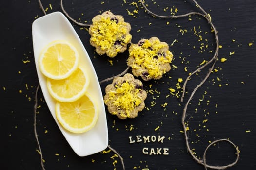 lemon cupcakes on a black background with lemon zest, lemon cake inscription