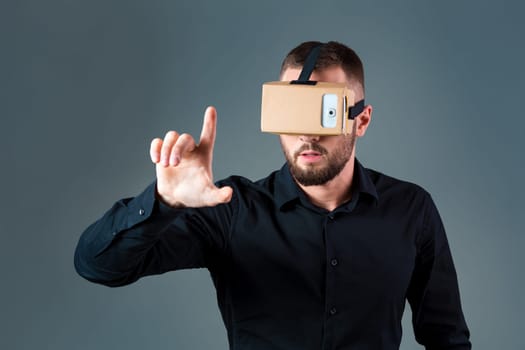 Man using a new virtual reality headset on grey background. Men's emotions