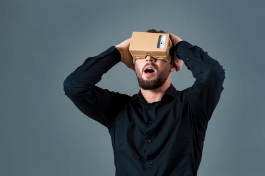 Man using a new virtual reality headset on grey background. Men's emotions
