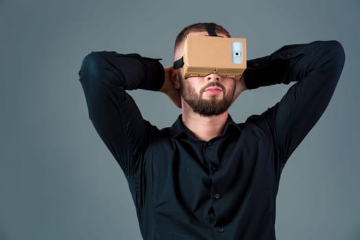 Man using a new virtual reality headset on grey background. Men's emotions