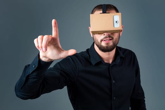 Man using a new virtual reality headset on grey background. Men's emotions