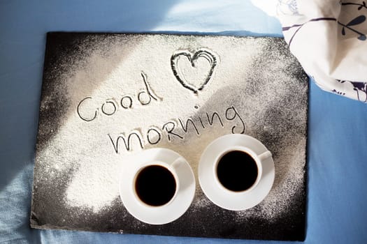 good morning inscription flour on a board with cups of coffee, heart Valentine's day.