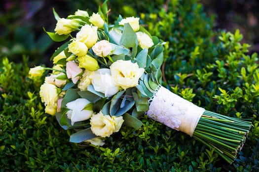 beautiful bridal bouquet lying on the green grass