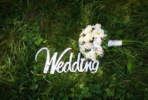Word of wedding and bridal bouquet outdoor.