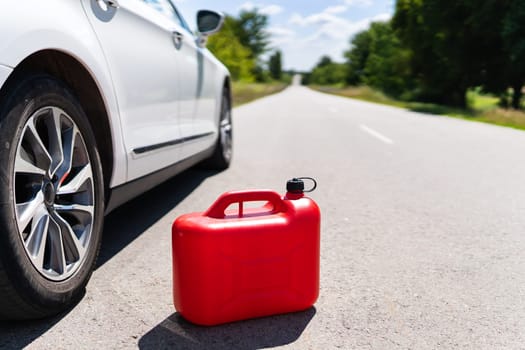 Empty car tank from a red canister on the side of the road. Fuel problem