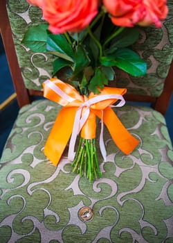 wedding bouquet with red flowers on a chair with a ring