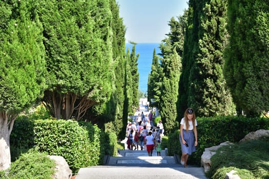 Partenit, Crimea - July 8. 2019. The People walk along the alley to the sea in Park landscape art Aivazovskoe