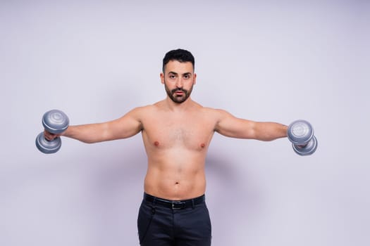 Athletic man doing exercises with dumbbell at biceps on a white background. Strength and motivation