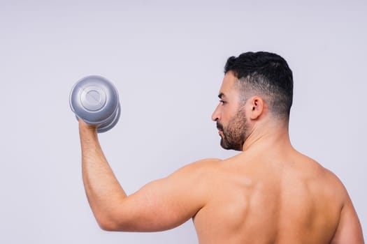 Athletic man doing exercises with dumbbell at biceps on a white background. Strength and motivation