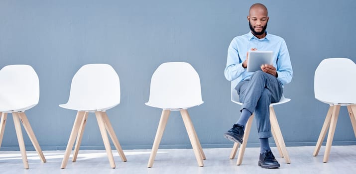 Waiting room, tablet and black man sitting at job opportunity, career application or Human Resources interview. Professional person or worker search online website for hr recruitment or hiring email.